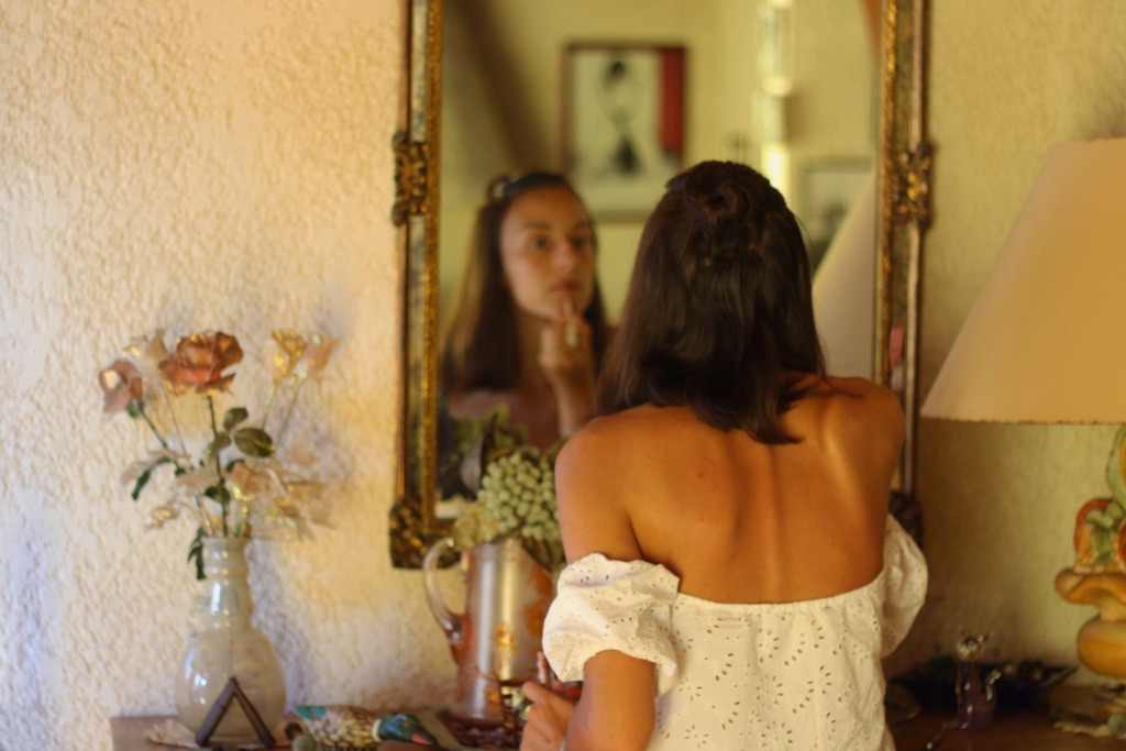 femme se maquillant face à un miroir